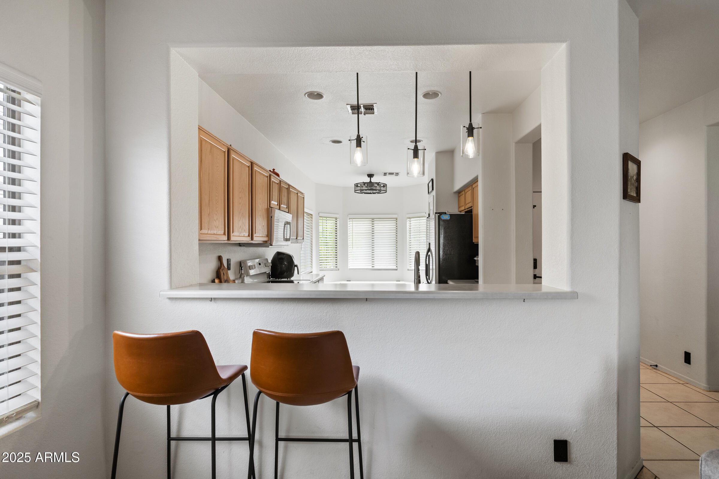 1140 South Rockwell Street Gilbert, AZ 85296 - Photo 8 of 29 a kitchen with stainless steel appliances kitchen island granite countertop a table chairs and a refrigerator