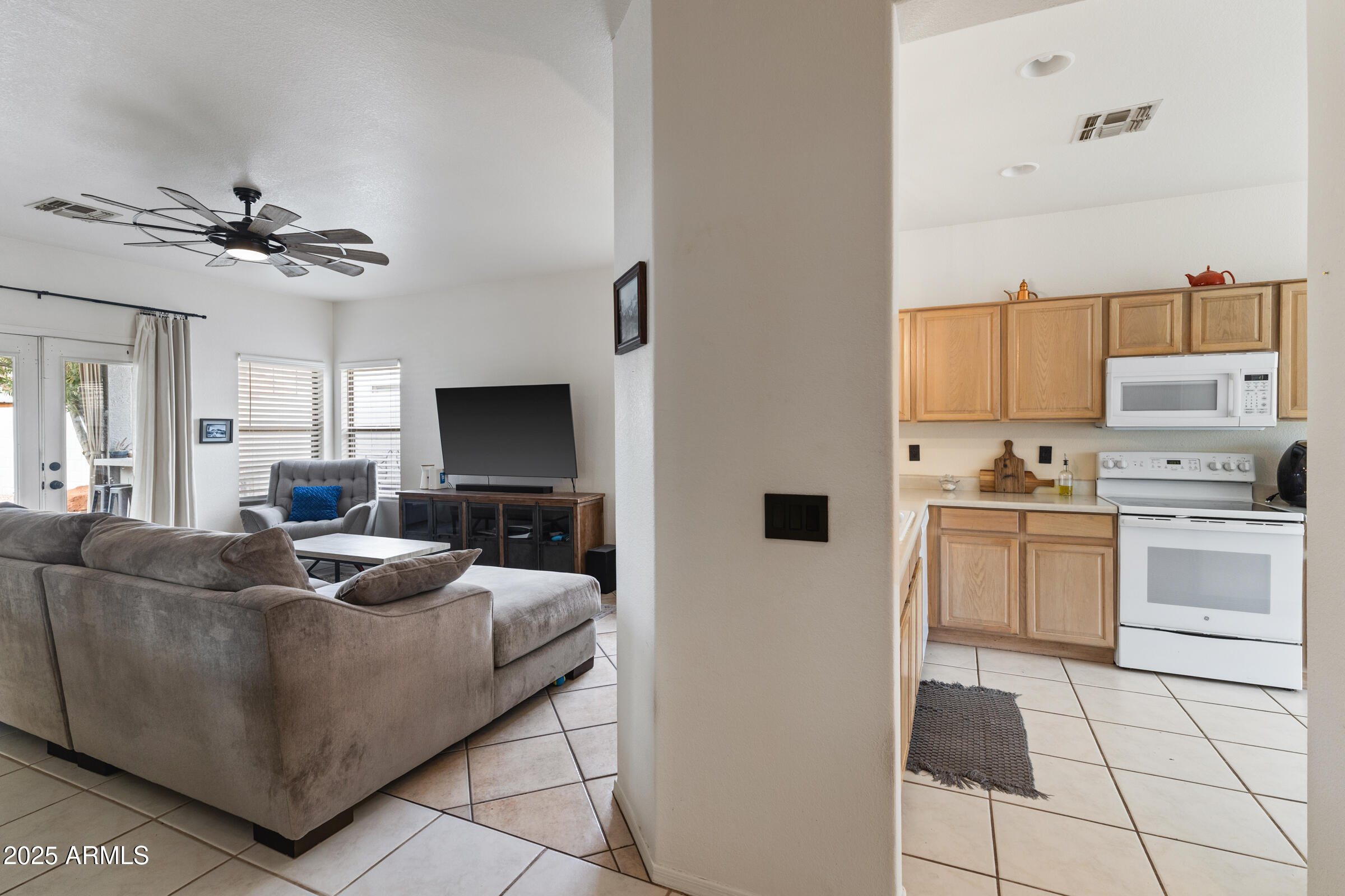 1140 South Rockwell Street Gilbert, AZ 85296 - Photo 9 of 29 a living room with furniture a flat screen tv and kitchen view