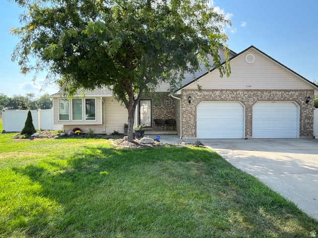 2548 South 700 West Perry, UT 84302 - Photo 1 of 18 View of front of home with concrete driveway, an attached garage, brick siding, and a patio area