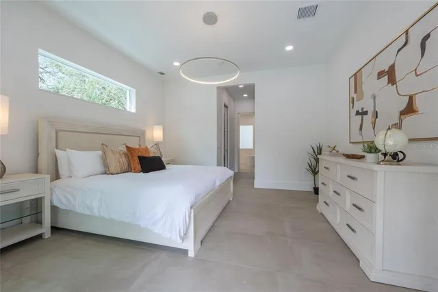 a bedroom with a bed and a large window