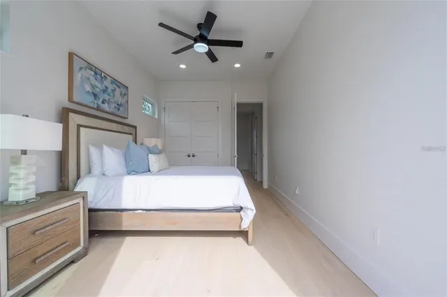 a bedroom with a large bed and a chandelier