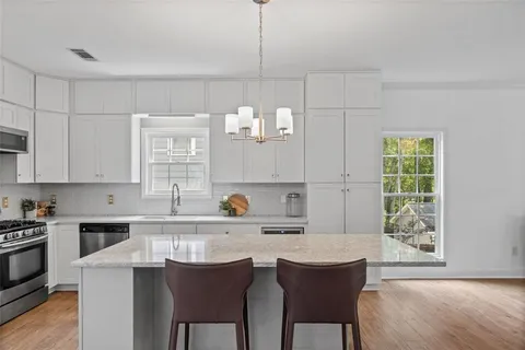 a kitchen with a dining table chairs and a window