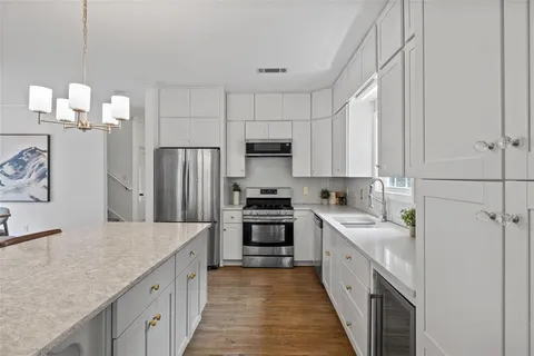 a kitchen with stainless steel appliances a sink stove refrigerator and cabinets