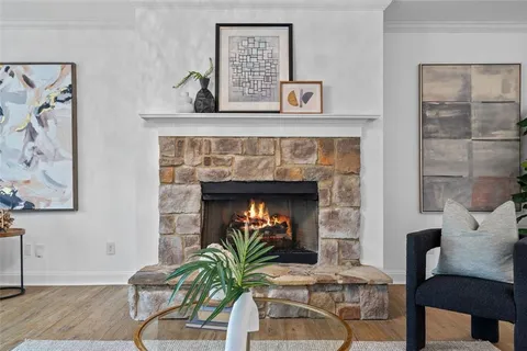 a living room with a fireplace and a potted plant