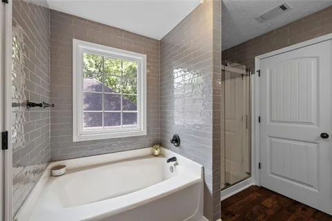 a bathroom with a tub a window and a shower