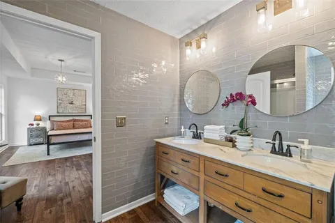 a bathroom with a double vanity sink mirror and shower