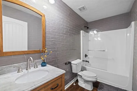 a bathroom with a sink toilet vanity and shower