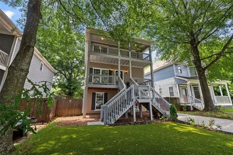 a view of a house with a yard and a wooden deck