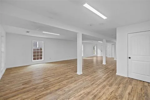 a view of empty room with wooden floor