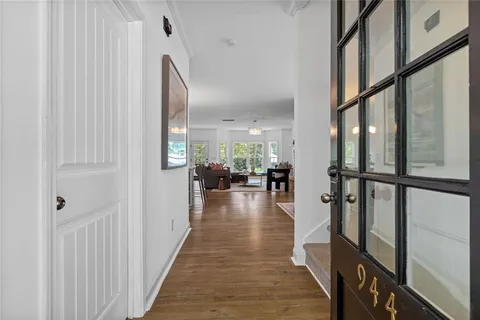 a hallway with a large window and wooden floor