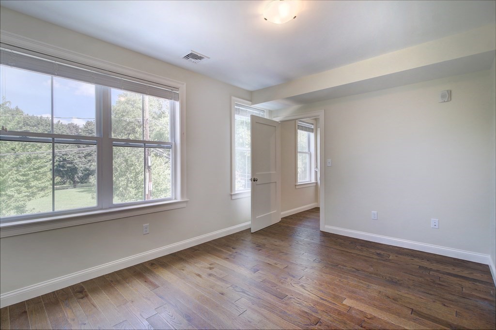 4 Kemp Street, Unit 4 Boston, MA 02127 - Photo 13 of 40 a view of an empty room with wooden floor and a window