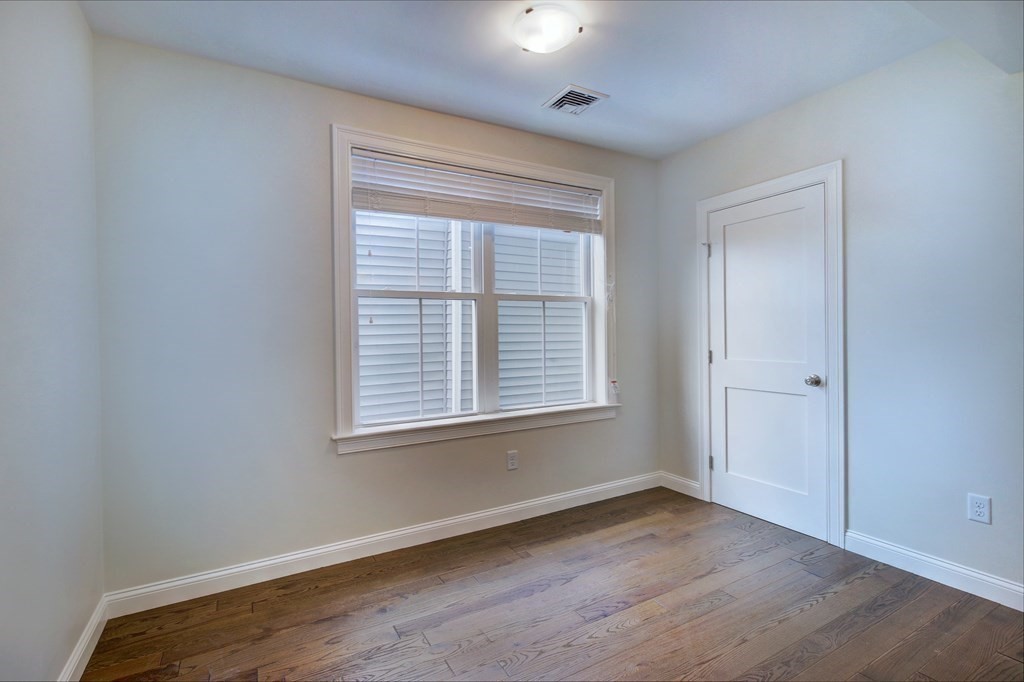 4 Kemp Street, Unit 4 Boston, MA 02127 - Photo 14 of 40 a view of an empty room with wooden floor and a window