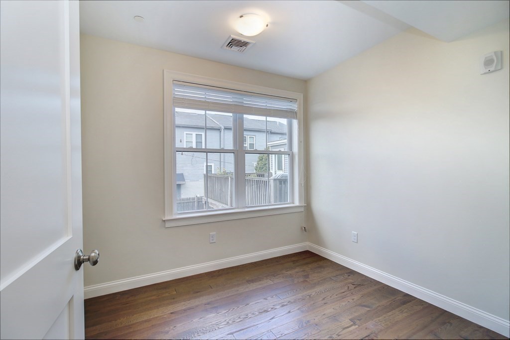 4 Kemp Street, Unit 4 Boston, MA 02127 - Photo 18 of 40 an empty room with wooden floor and windows