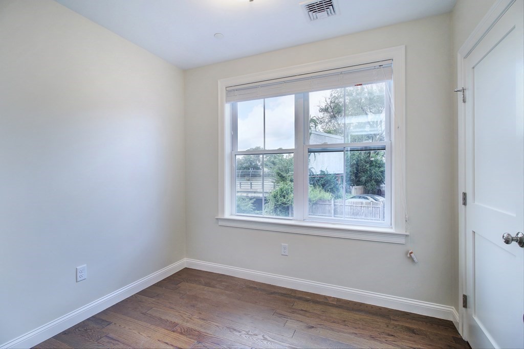 4 Kemp Street, Unit 4 Boston, MA 02127 - Photo 20 of 40 an empty room with wooden floor and windows