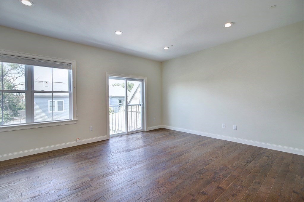 4 Kemp Street, Unit 4 Boston, MA 02127 - Photo 22 of 40 an empty room with wooden floor and windows