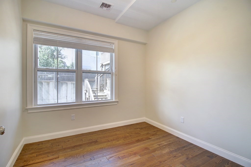 4 Kemp Street, Unit 4 Boston, MA 02127 - Photo 32 of 40 a view of an empty room with wooden floor and a window