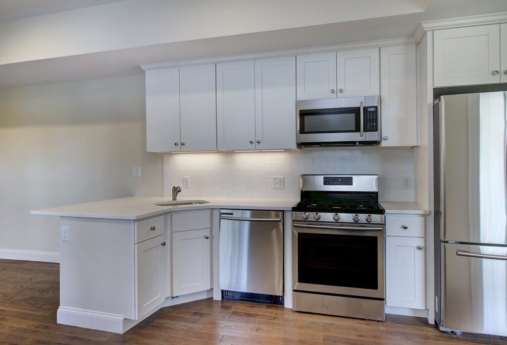 4 Kemp Street, Unit 4 Boston, MA 02127 - Photo 34 of 40 a kitchen with stainless steel appliances granite countertop a stove a refrigerator and a microwave