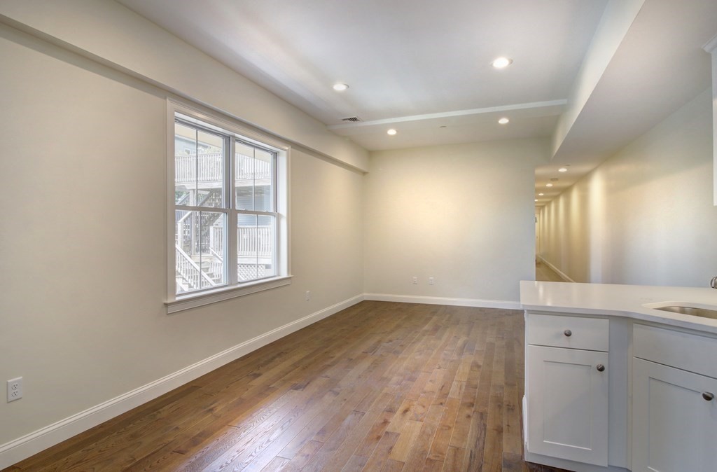 4 Kemp Street, Unit 4 Boston, MA 02127 - Photo 35 of 40 an empty room with wooden floor and windows