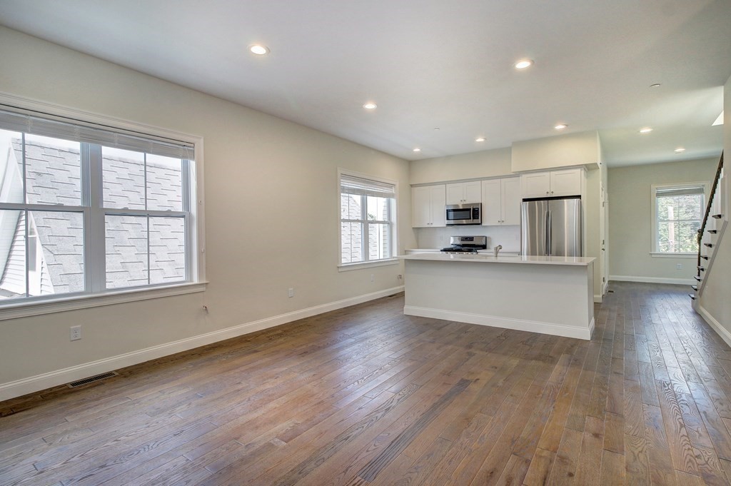 4 Kemp Street, Unit 4 Boston, MA 02127 - Photo 7 of 40 an open kitchen with white cabinets and stainless steel appliances