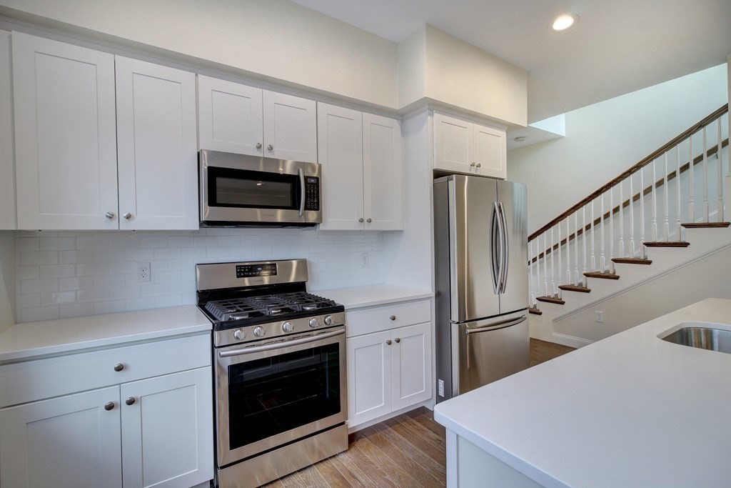 4 Kemp Street, Unit 4 Boston, MA 02127 - Photo 9 of 40 a kitchen with granite countertop a stove a microwave and refrigerator