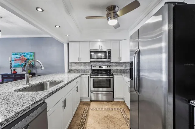 a kitchen with kitchen island granite countertop a sink stainless steel appliances and counter space