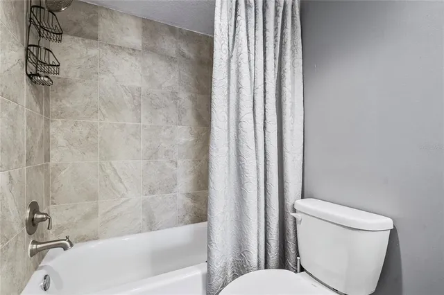 a view of a swimming pool with lawn chairs and iron fence