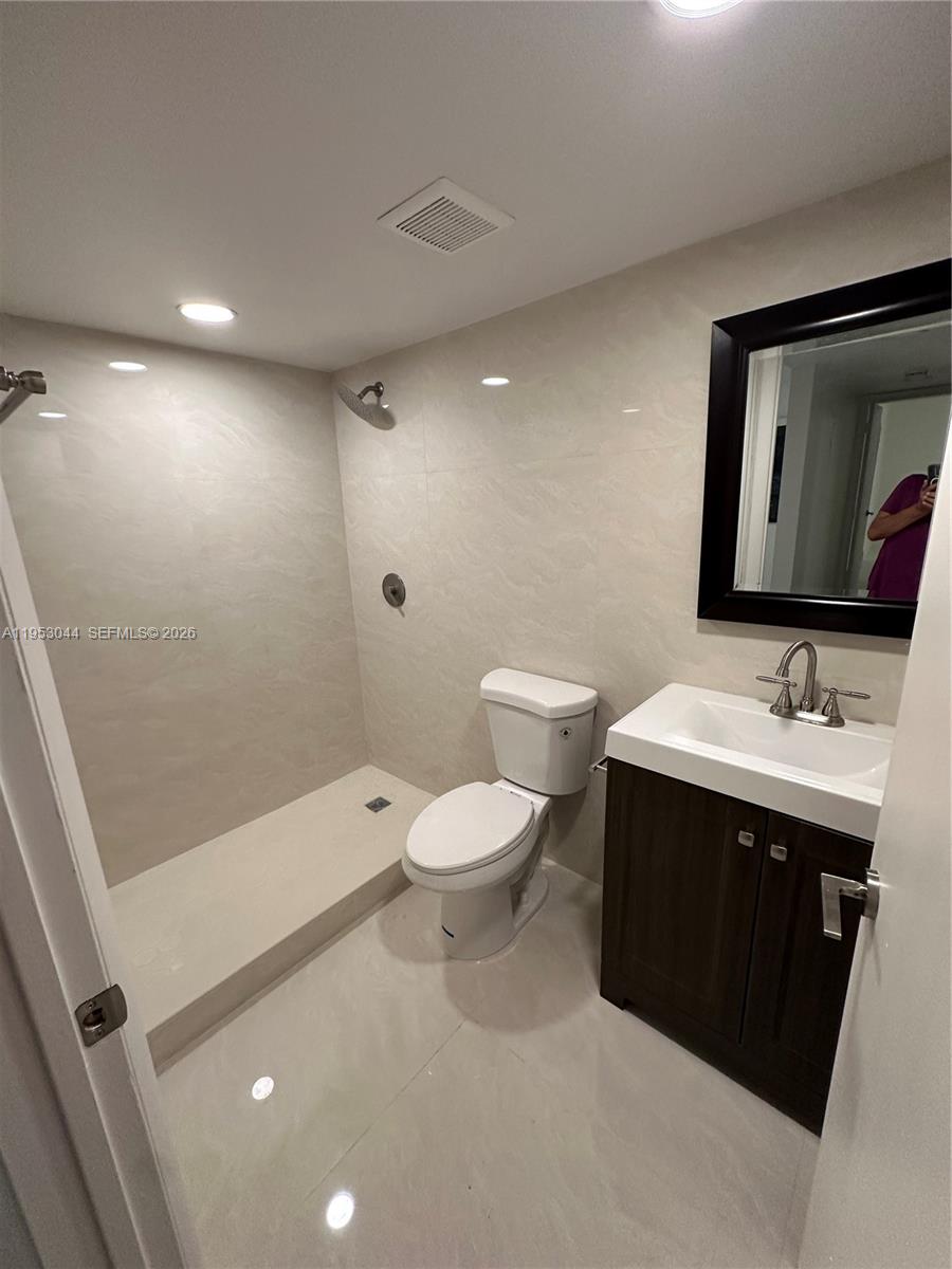 9015 Southwest 125th Avenue, Unit N209 Miami, FL 33186 - Photo 11 of 18 a bathroom with a toilet sink and mirror