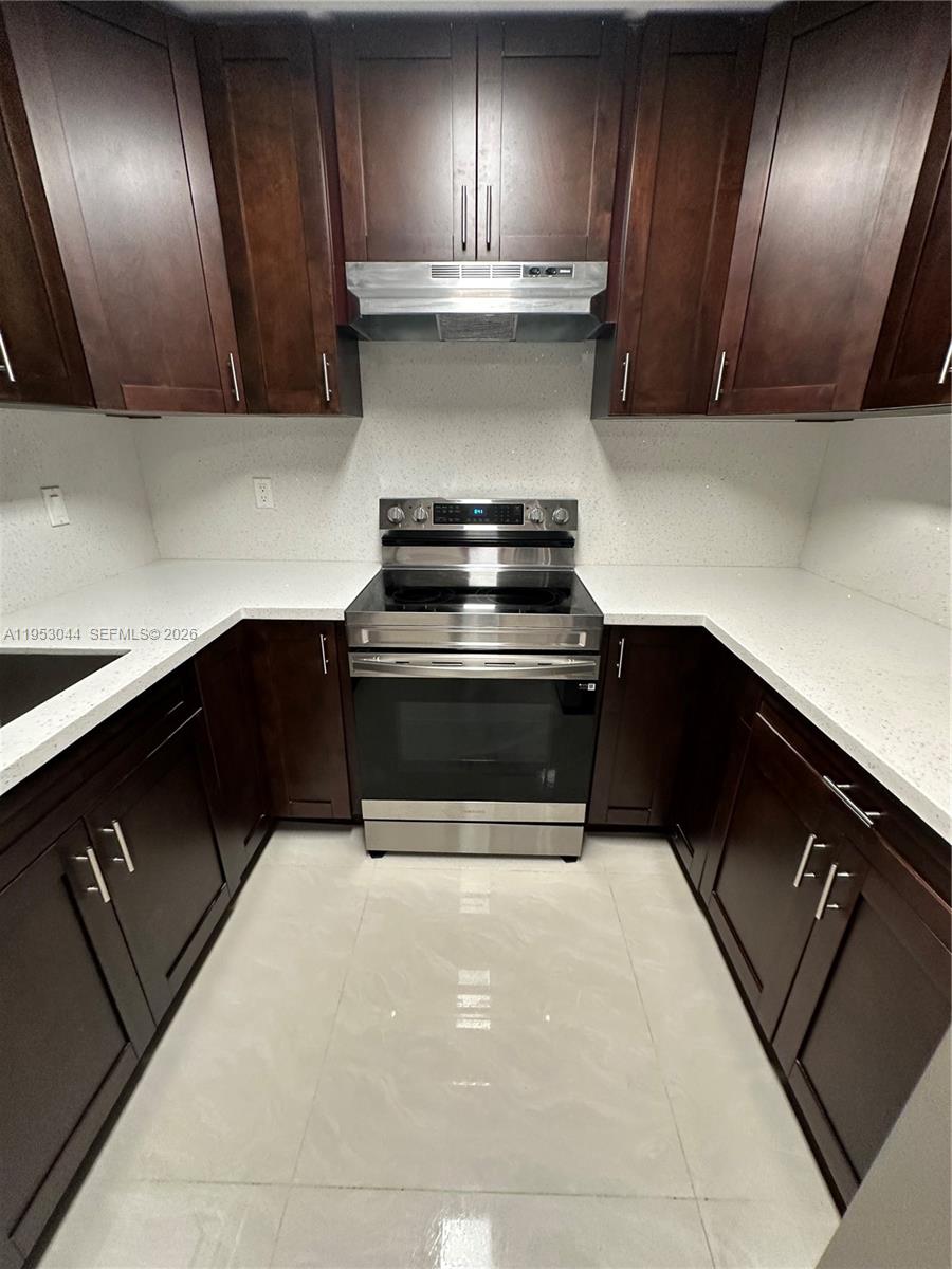 9015 Southwest 125th Avenue, Unit N209 Miami, FL 33186 - Photo 6 of 18 a kitchen with granite countertop stainless steel appliances and cabinets