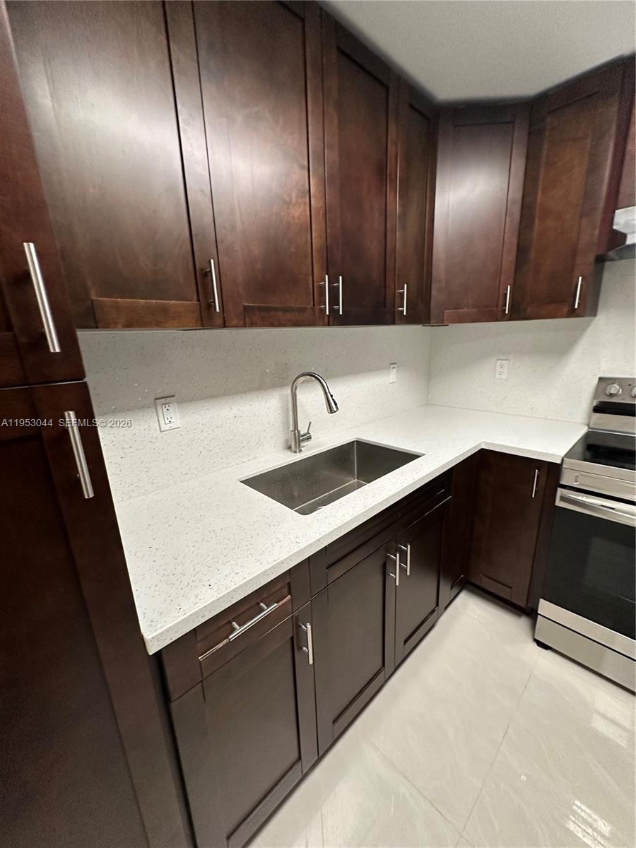 9015 Southwest 125th Avenue, Unit N209 Miami, FL 33186 - Photo 7 of 18 a kitchen with a sink and cabinets