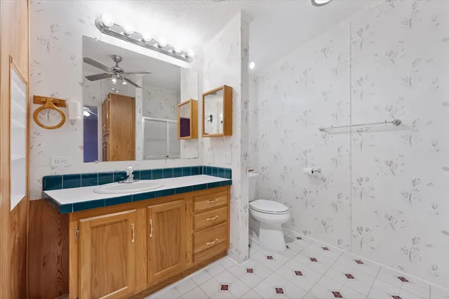 a bathroom with a granite countertop toilet sink and mirror