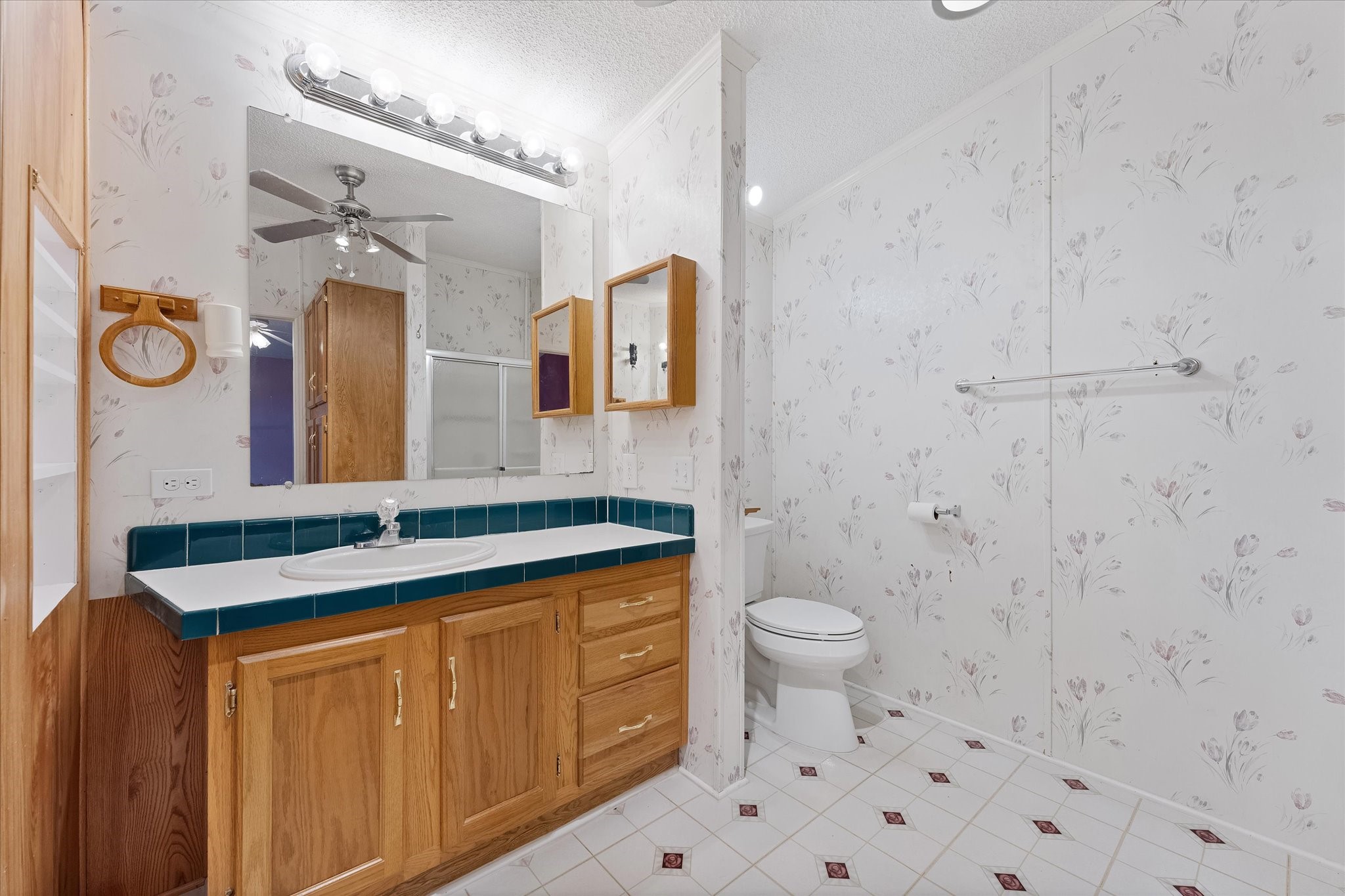 23419 Quiet Hollow Road Montgomery, TX 77356 - Photo 12 of 46 a bathroom with a granite countertop toilet sink and mirror