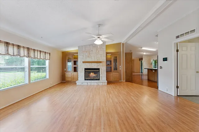 a view of an empty room with a window and a kitchen