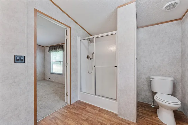 a bathroom view of a toilet and a shower