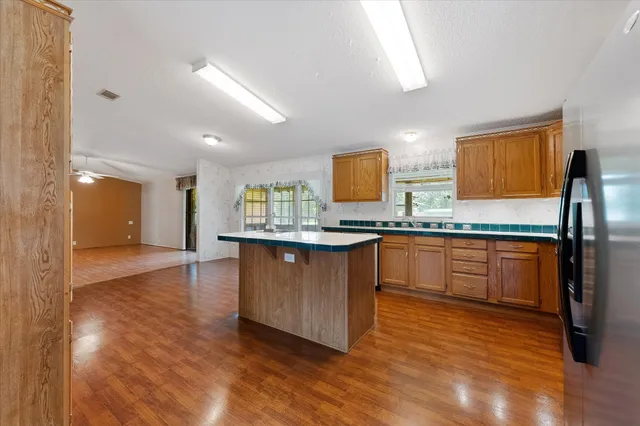 a kitchen with wooden floors and refrigerator