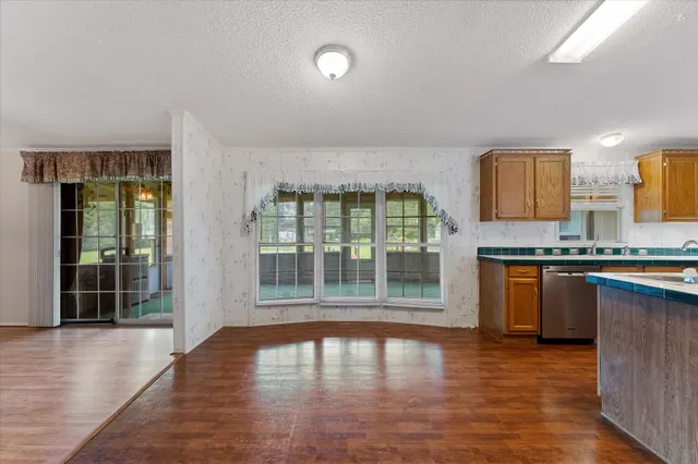 a view of a kitchen with granite countertop a large window and a sink