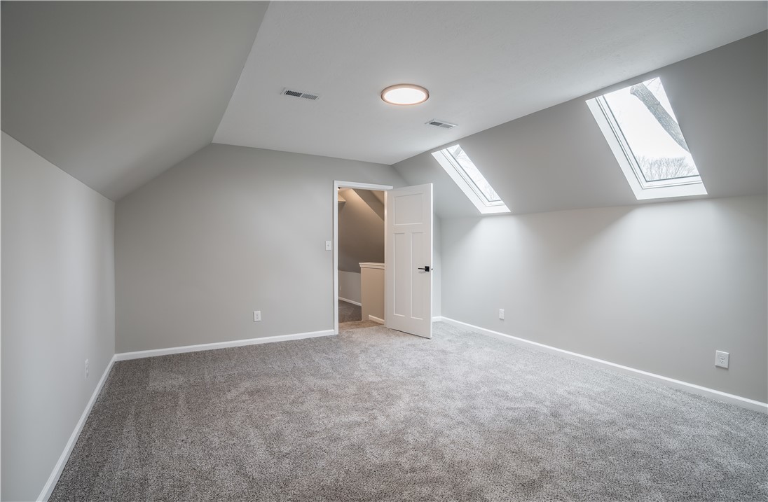 8240 Looney Road Piqua, OH 45356 - Photo 29 of 49 Bright and airy, this room features sloped ceilings and ample natural light, creating a versatile space.