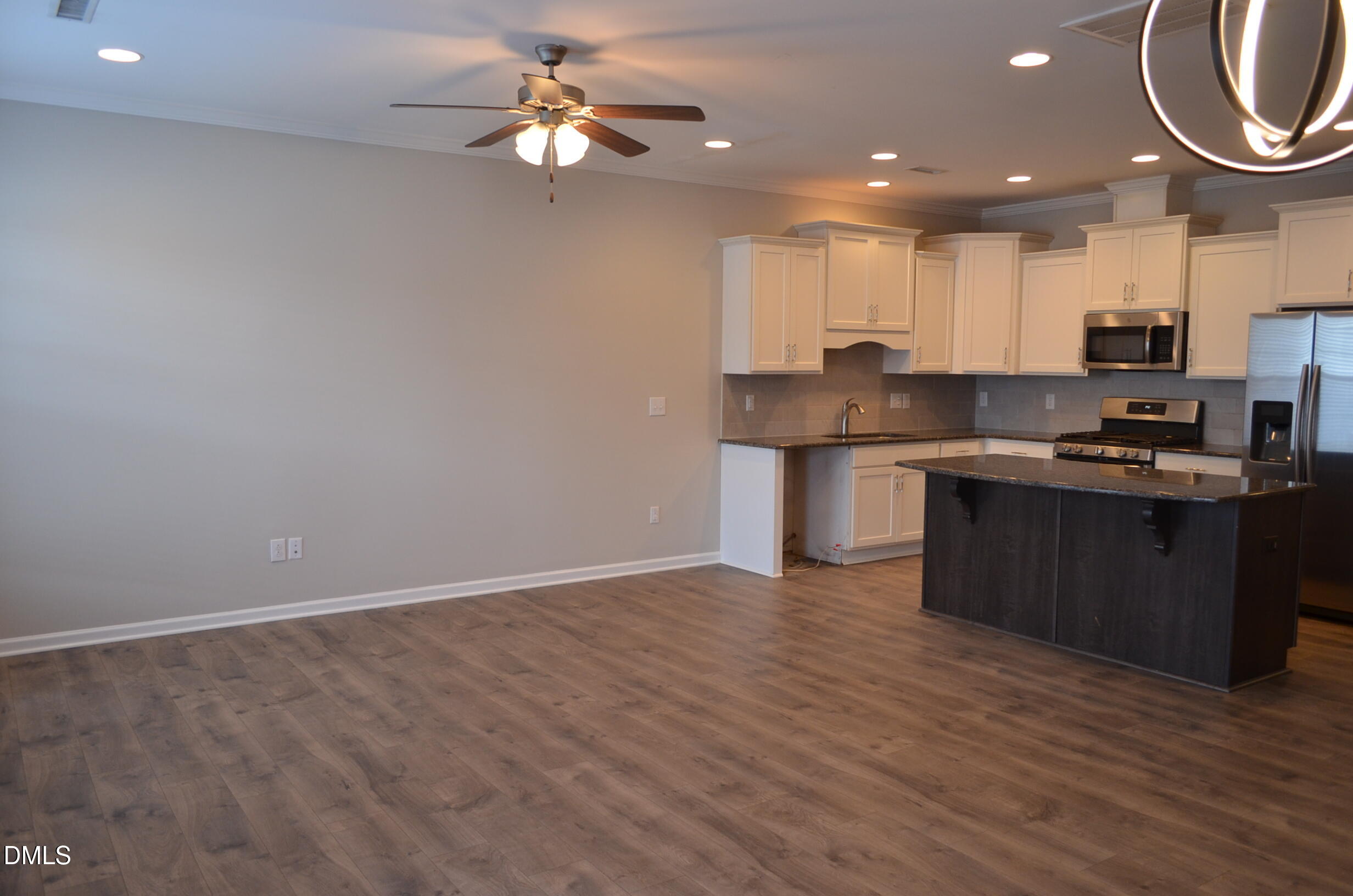 6506 Perry Creek Road, Unit 1103 Raleigh, NC 27616 - Photo 14 of 34 a kitchen with stainless steel appliances granite countertop a sink a stove top oven a chimney and a counter top space