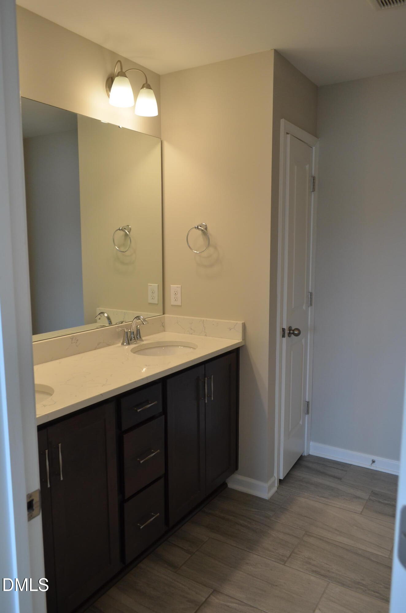 6506 Perry Creek Road, Unit 1103 Raleigh, NC 27616 - Photo 26 of 34 a bathroom with a double vanity sink and a mirror