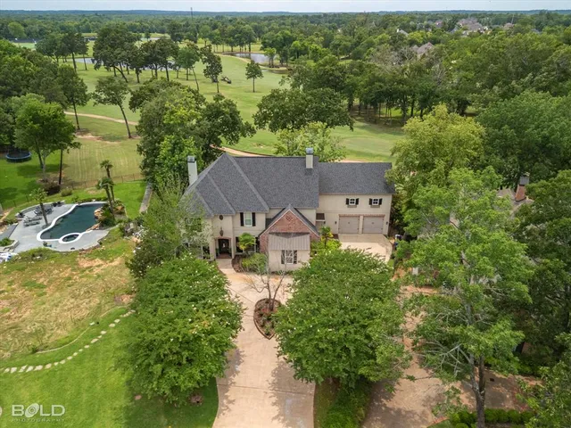 an aerial view of a house with a yard and lake view