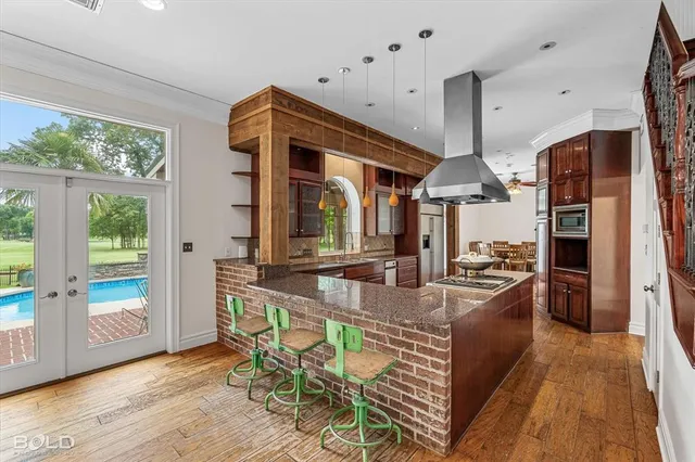 a kitchen with stainless steel appliances granite countertop a sink a stove and a refrigerator