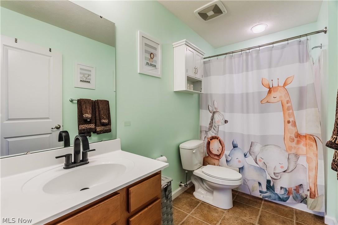 6687 List Street Northwest Canton, OH 44708 - Photo 15 of 21 Full bathroom with a shower with curtain, vanity, and dark tile patterned flooring
