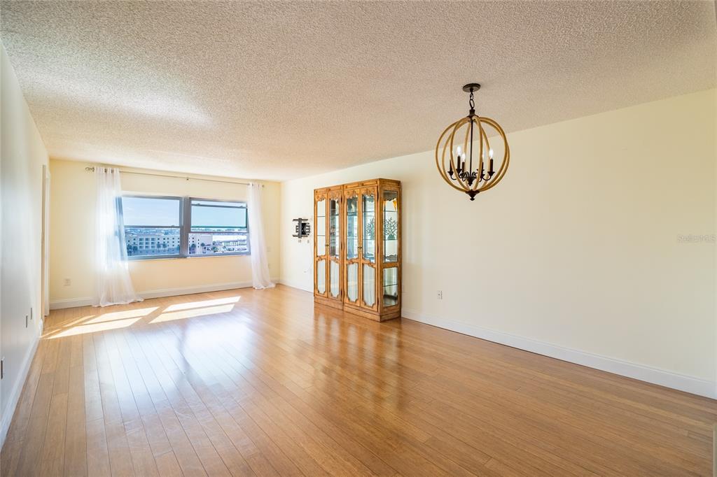 4775 Cove Circle, Unit 1002 Madeira Beach, FL 33708 - Photo 12 of 60 a view of an empty room with wooden floor and a window