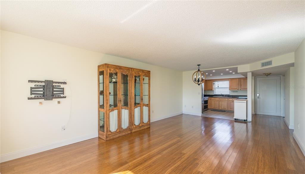 4775 Cove Circle, Unit 1002 Madeira Beach, FL 33708 - Photo 14 of 60 a view of an empty room with wooden floor and a window