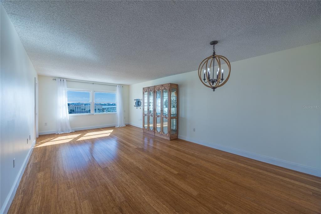 4775 Cove Circle, Unit 1002 Madeira Beach, FL 33708 - Photo 15 of 60 a view of an empty room with wooden floor and a window