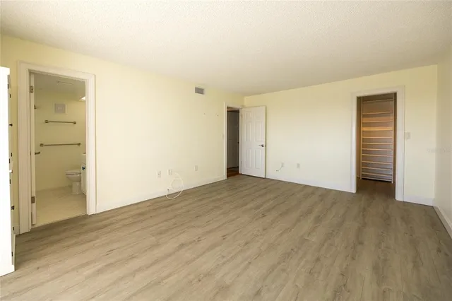 an empty room with wooden floor & windows
