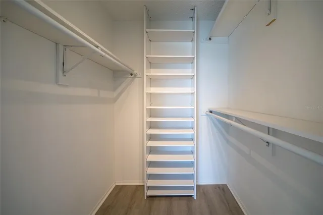 a view of walk in closet with empty racks