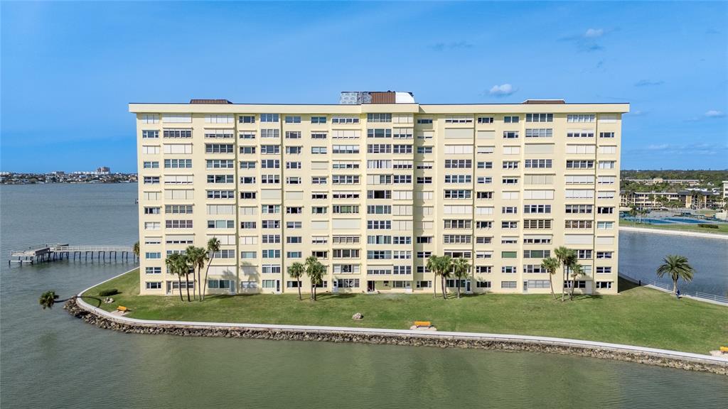 4775 Cove Circle, Unit 1002 Madeira Beach, FL 33708 - Photo 48 of 60 a view of a large building with a yard