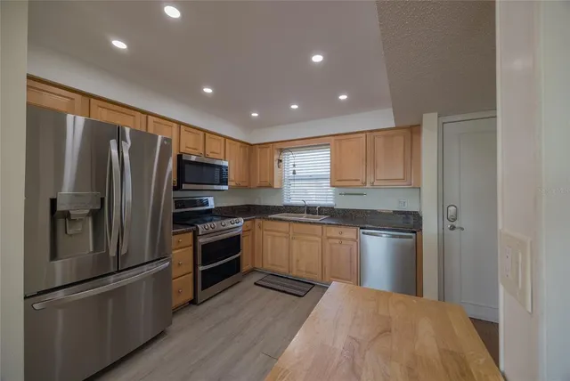 a kitchen with granite countertop stainless steel appliances and refrigerator