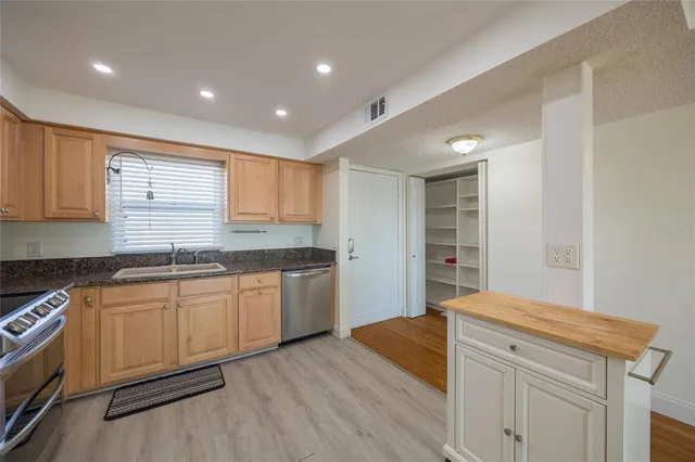 a kitchen with granite countertop white cabinets and white appliances