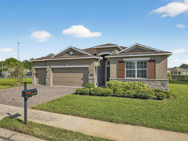 a front view of a house with a yard and potted plants